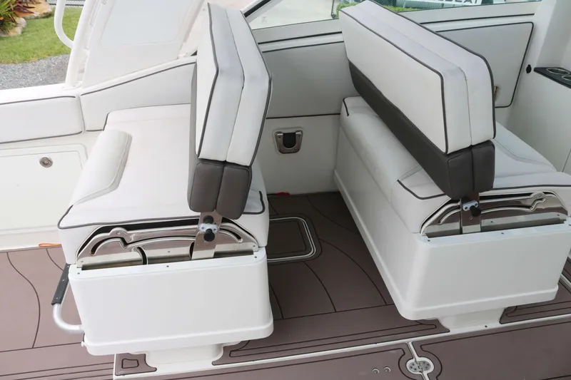 Slide: The Image of 2017 World Cat 320DC boat interior seating with white cushions and brown flooring. - 11