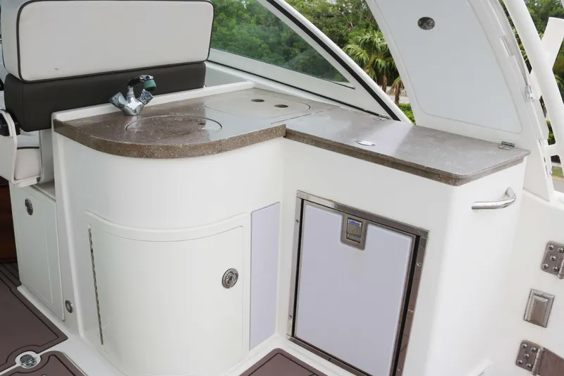 Slide: The Image of 2017 World Cat 320DC boat interior with sink, countertop, and storage. - 13