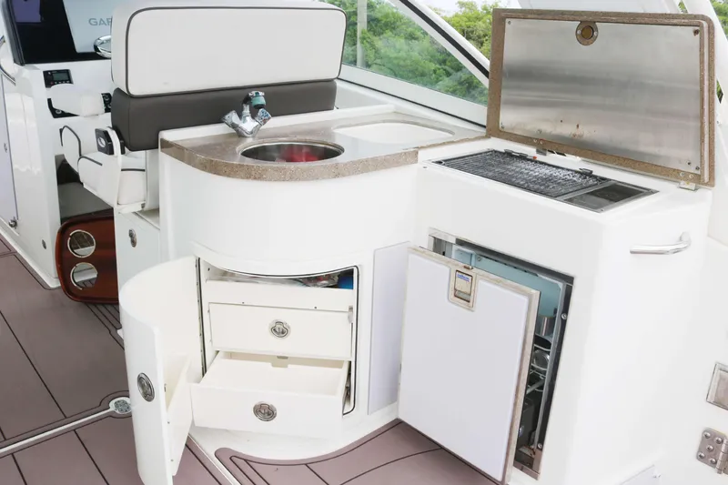 Slide: The Image of 2017 World Cat 320DC boat interior with sink, grill, and storage drawers. - 14