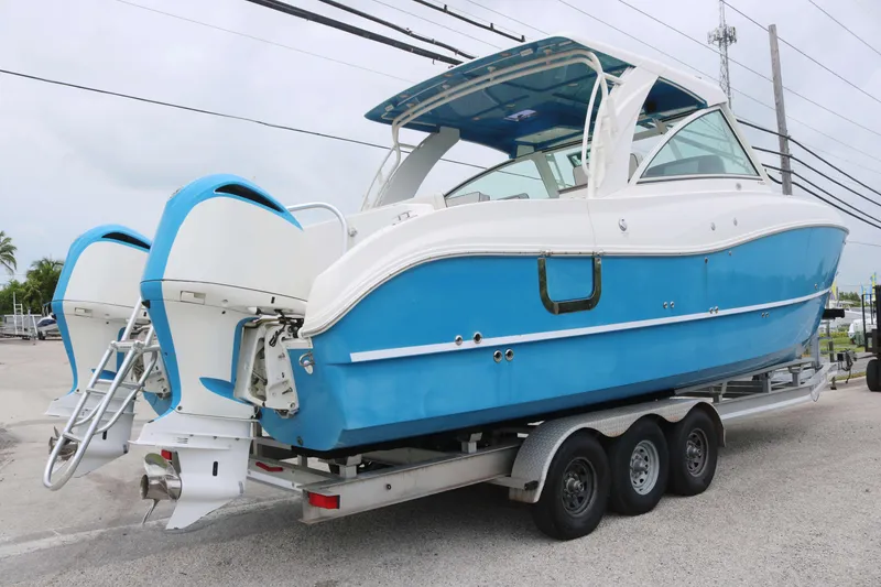 Slide: The Image of 2017 World Cat 320DC boat on trailer, featuring dual outboard engines and blue hull. - 3