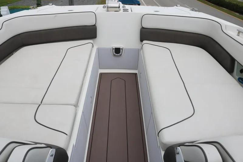 Slide: The Image of 2017 World Cat 320DC boat interior with white cushioned seating and brown flooring. - 7