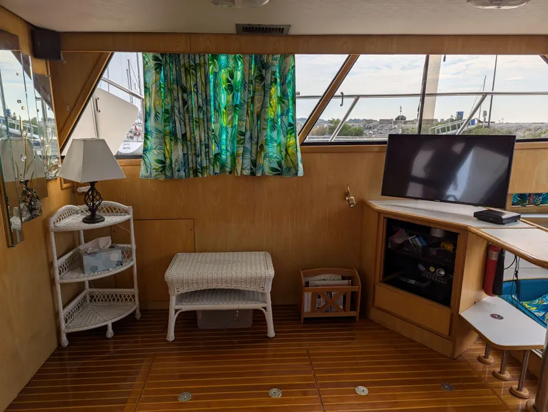 Slide: The Image of Cozy boat interior with tropical curtains, wicker furniture, and a TV, Custom Hi-tech 44, 1988. - 12