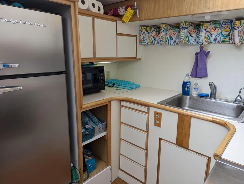 Slide: The Image of Compact kitchen with Frigidaire fridge, microwave, and sink in a 1988 Custom Hi-tech 44. - 16