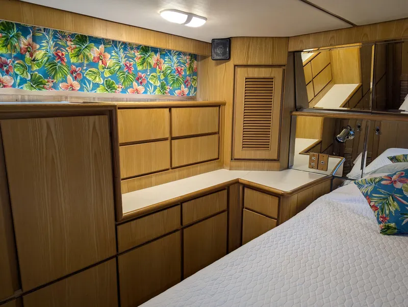Slide: The Image of Wood-paneled room with floral curtains, mirrored accents, and a quilted bedspread, in a 1988 Custom Hi-tech 44. - 21