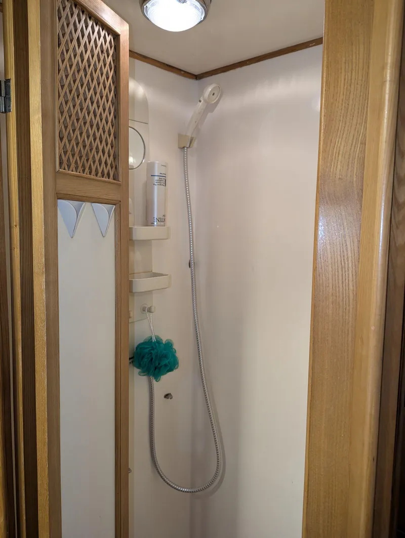 Slide: The Image of Compact shower area in a 1988 Custom Hi-tech 44, featuring wooden accents and modern fixtures. - 25