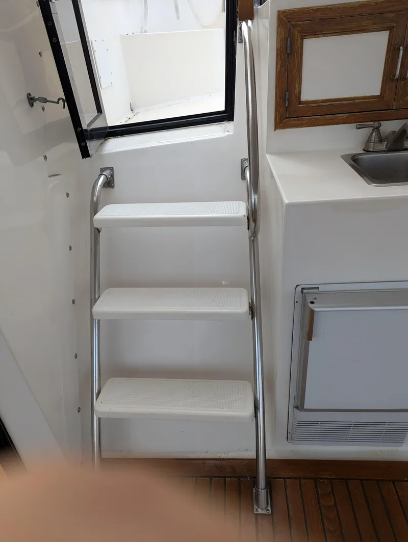Slide: The Image of Stainless steel boat ladder with three steps, adjacent to a sink and wooden cabinet. - 4