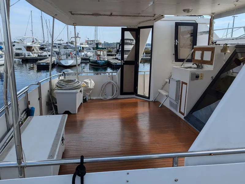 Slide: The Image of Spacious deck of 1988 Custom Hi-tech 44 yacht docked at marina with wooden flooring. - 7