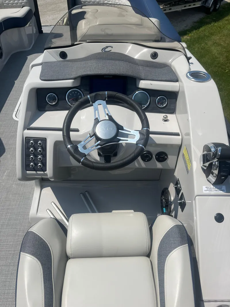 Slide: The Image of 2022 Crest Caribbean LX 250 CP3 boat dashboard with steering wheel and controls. - 6