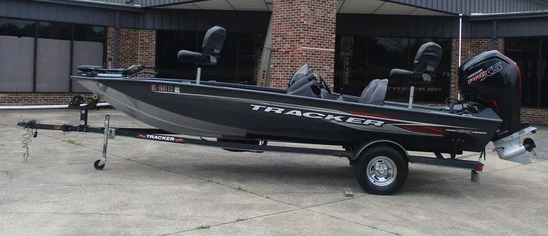 The Image of 2021 Tracker Pro Team™ 190 TX boat on trailer, parked outside a building. - 1
