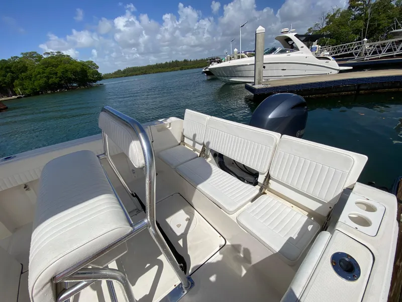 Slide: The Image of Interior of a 2018 Release 208 SXC boat with white seating and scenic marina view. - 16