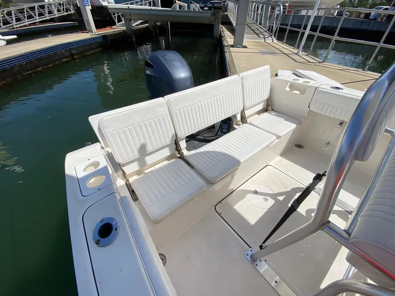 Slide: The Image of 2018 Release 208 SXC boat interior with white seating at a marina dock. - 17