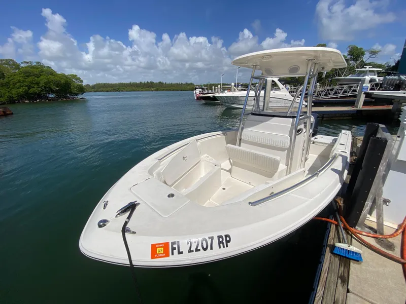 Slide: The Image of 2018 Release 208 SXC boat docked by the water on a sunny day. - 20