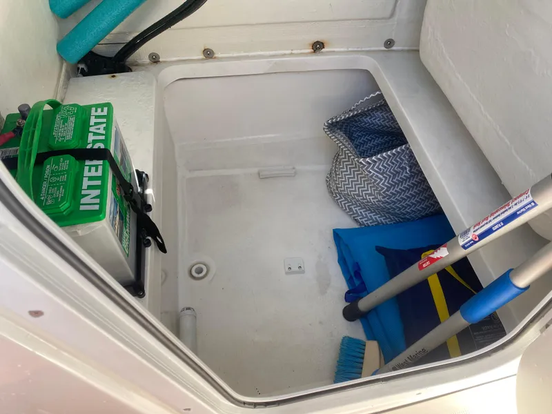 Slide: The Image of Storage compartment of 2018 Release 208 SXC with battery, pool noodles, and cleaning supplies. - 21
