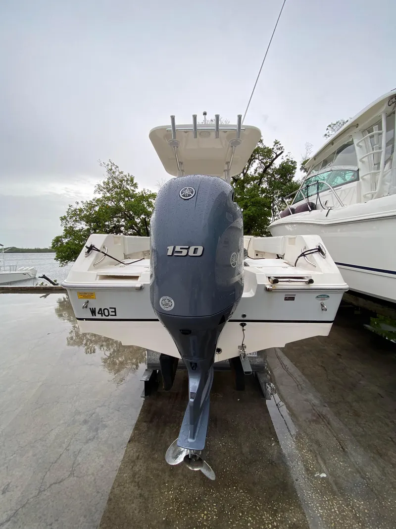 Slide: The Image of 2018 Release 208 SXC boat with 150 HP outboard motor, docked outdoors. - 8