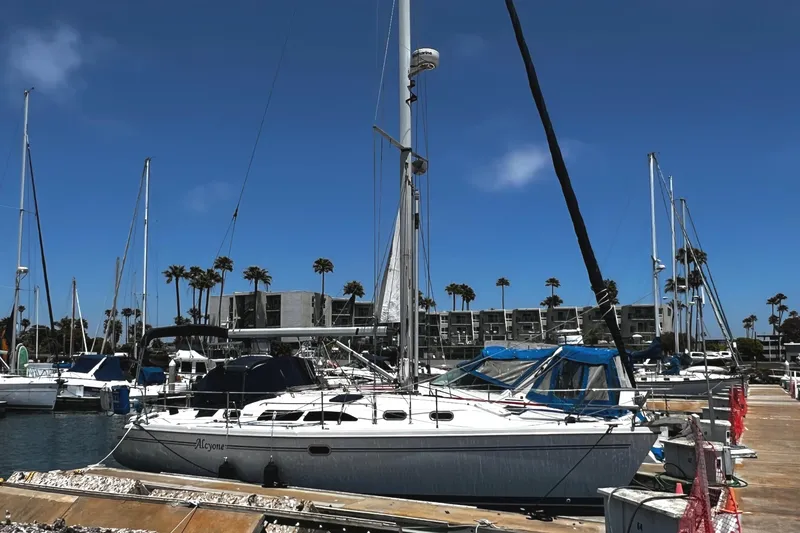 Slide: The Image of Catalina 350 sailboat docked at marina, clear blue sky, palm trees in background. - 10