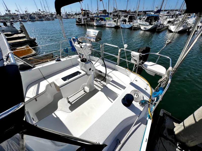 Slide: The Image of 2007 Catalina 350 sailboat docked in a marina, featuring a spacious cockpit and steering wheel. - 19