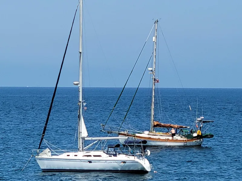 Slide: The Image of Two sailboats anchored on a calm sea, featuring a 2007 Catalina 350. - 3