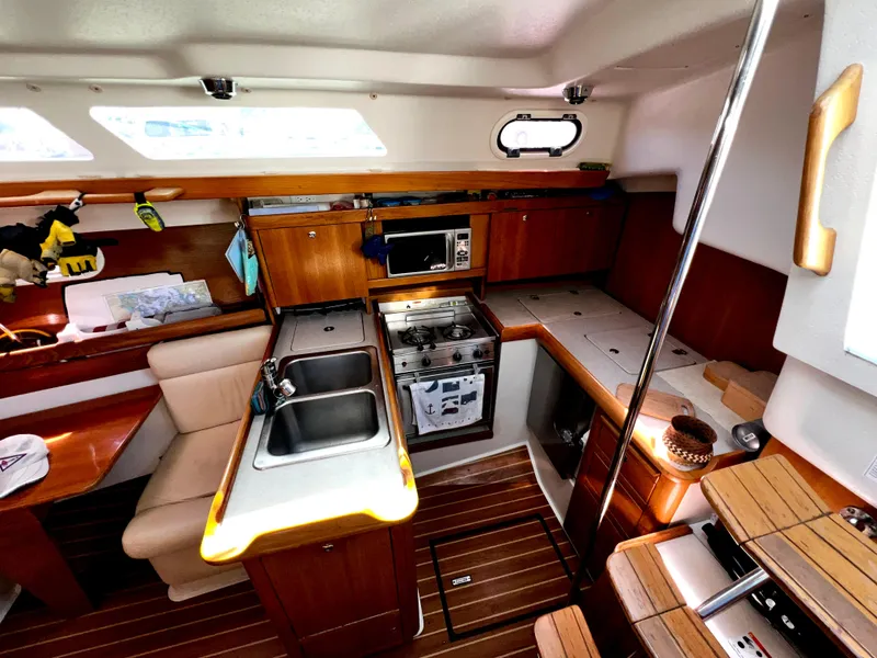 Slide: The Image of Interior of 2007 Catalina 350 sailboat kitchen with wood finish and modern appliances. - 37