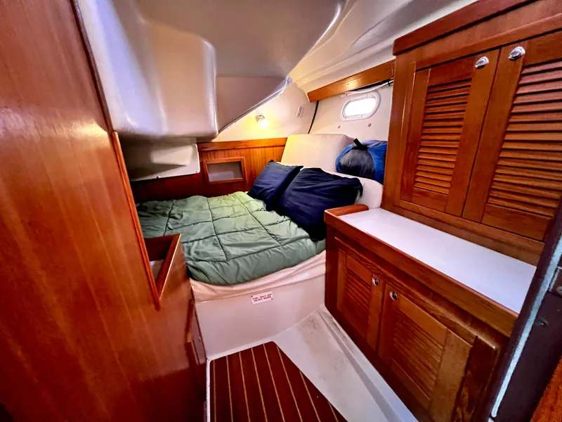 Slide: The Image of Cozy cabin interior of a 2007 Catalina 350 sailboat with wooden cabinetry and a comfortable bed. - 43