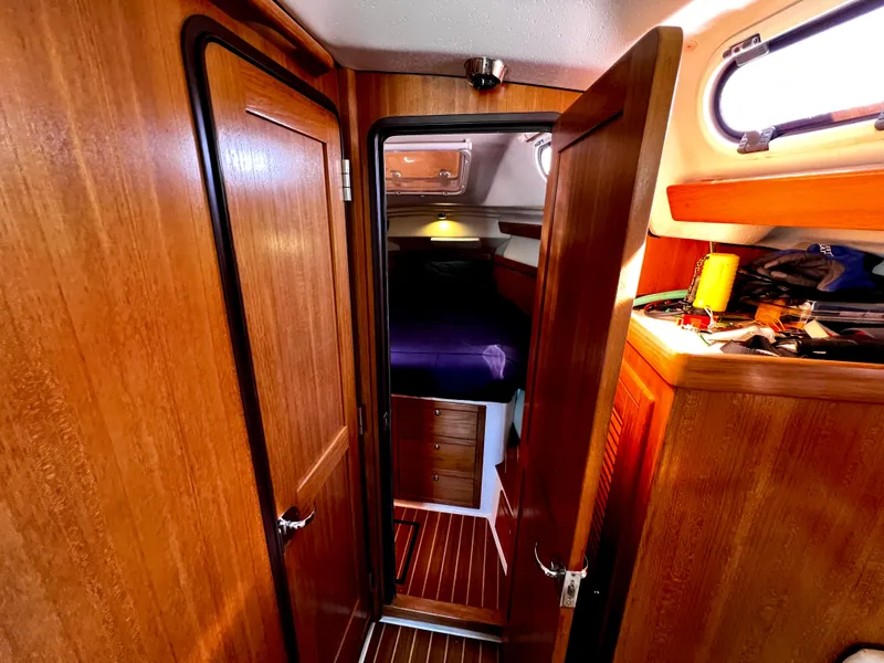 Slide: The Image of Interior of a 2007 Catalina 350 sailboat with wooden cabinetry and cozy sleeping quarters. - 44