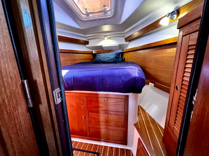 Slide: The Image of Cozy cabin interior of 2007 Catalina 350 sailboat with wooden furnishings and blue bedding. - 45