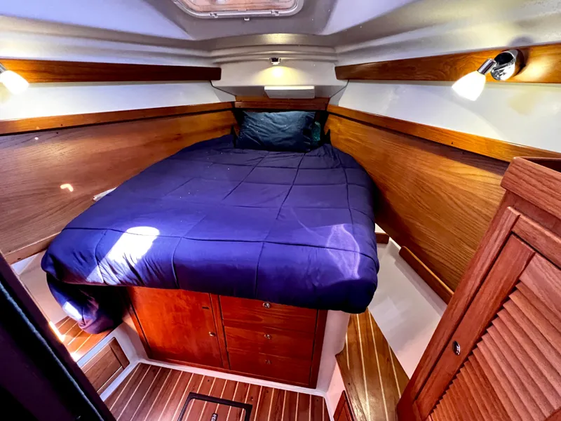 Slide: The Image of Cozy cabin interior of 2007 Catalina 350 sailboat with wooden finish and blue bedding. - 46