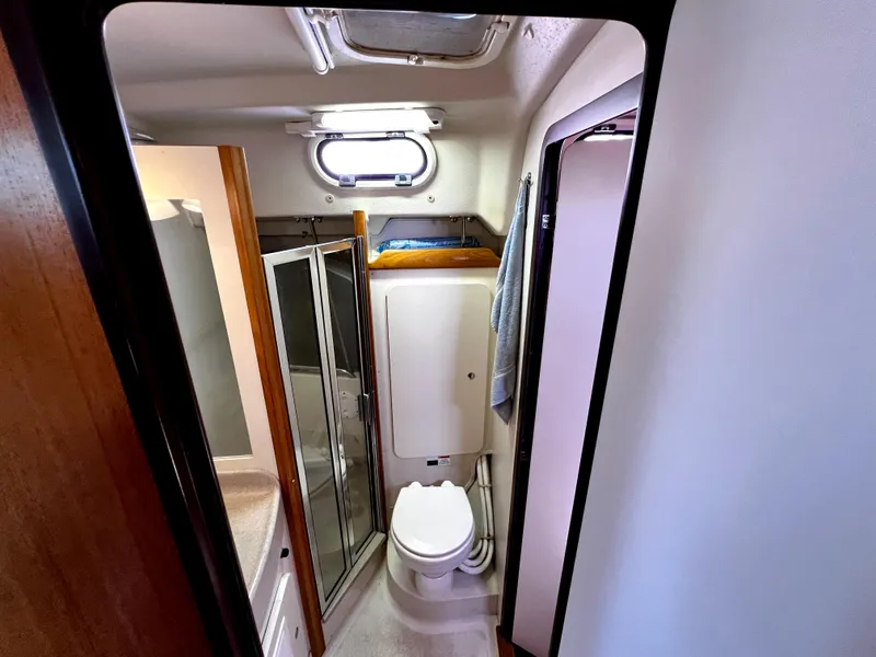 Slide: The Image of Compact bathroom in a 2007 Catalina 350 yacht, featuring a toilet and shower. - 49