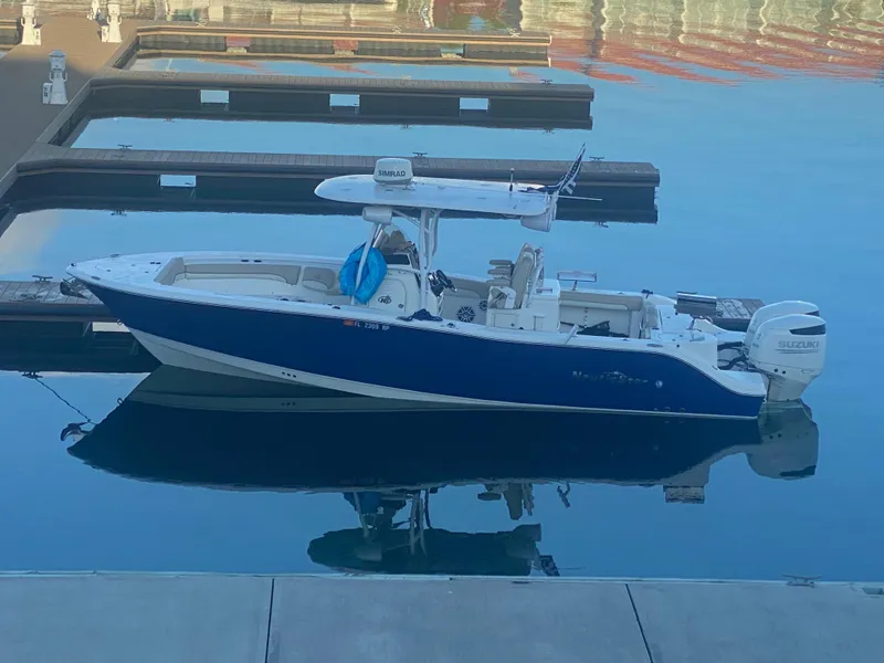 Slide: The Image of 2018 NauticStar 28 XS boat detail showing storage compartment and power outlet. - 17