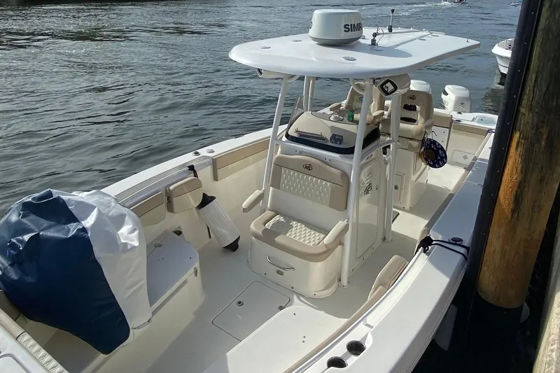 Slide: The Image of 2018 NauticStar 28 XS boat docked, featuring a sleek blue hull and modern design. - 2