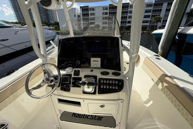 Slide: The Image of 2018 NauticStar 28 XS boat dashboard with steering wheel and control panel. - 24