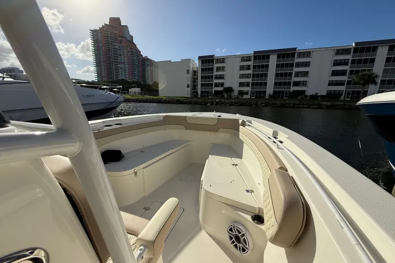 Slide: The Image of 2018 NauticStar 28 XS boat interior with seating, docked near waterfront buildings. - 37