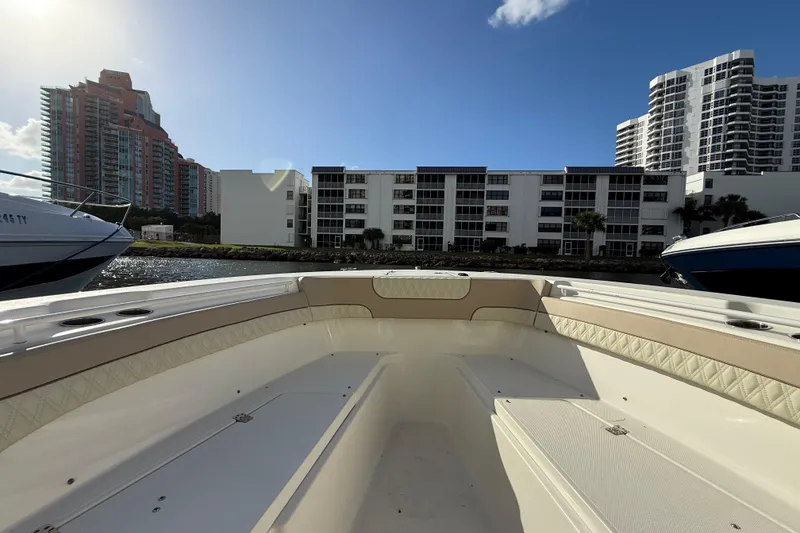 Slide: The Image of 2018 NauticStar 28 XS boat docked near waterfront buildings under a clear sky. - 38