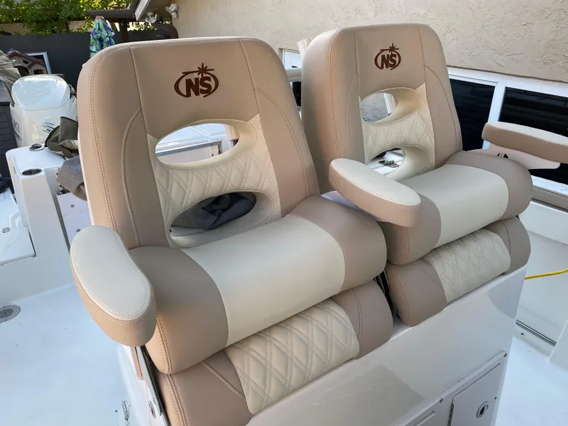 Slide: The Image of 2018 NauticStar 28 XS boat docked, featuring spacious seating and modern amenities. - 5