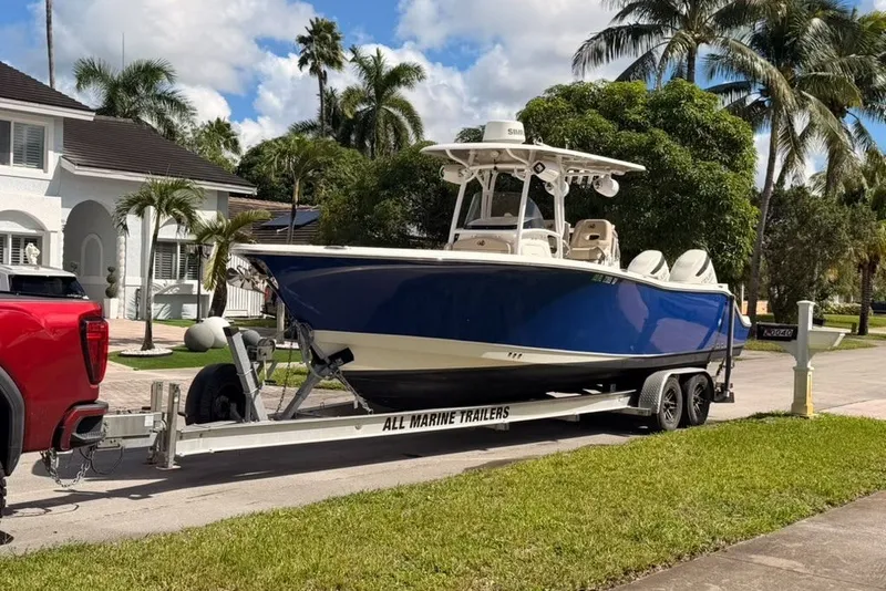 Slide: The Image of 2018 NauticStar 28 XS boat on trailer, parked in residential area with palm trees. - 45