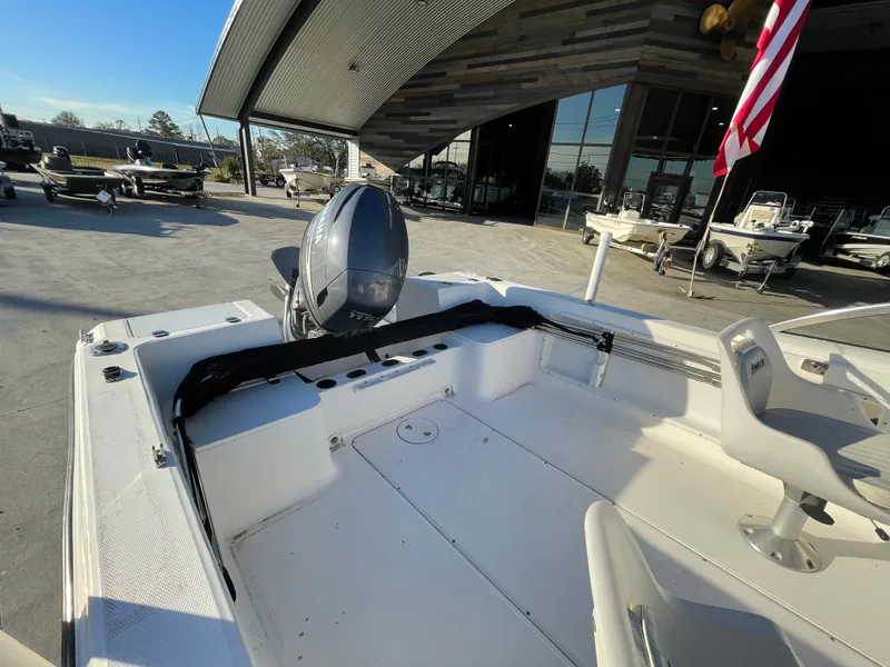 Slide: The Image of 2002 Angler 18 DC boat interior with steering wheel and seating under a canopy. - 10