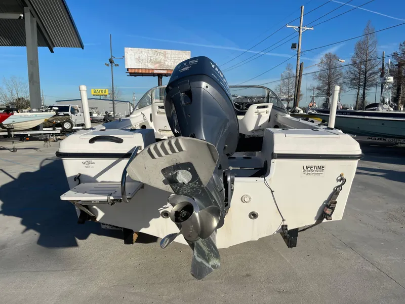 Slide: The Image of 2002 Angler 18 DC boat with Yamaha outboard motor on trailer, parked outdoors. - 2