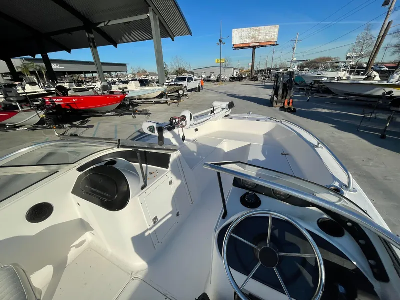 Slide: The Image of 2002 Angler 18 DC boat interior with motor, displayed outdoors near a showroom. - 9