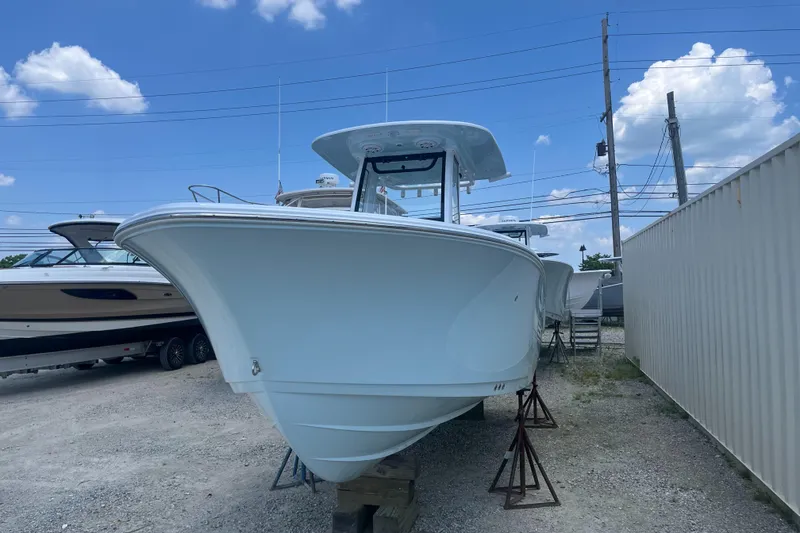 Slide: The Image of 2025 Sportsman Heritage 231 Center Console boat on display under a clear blue sky. - 3