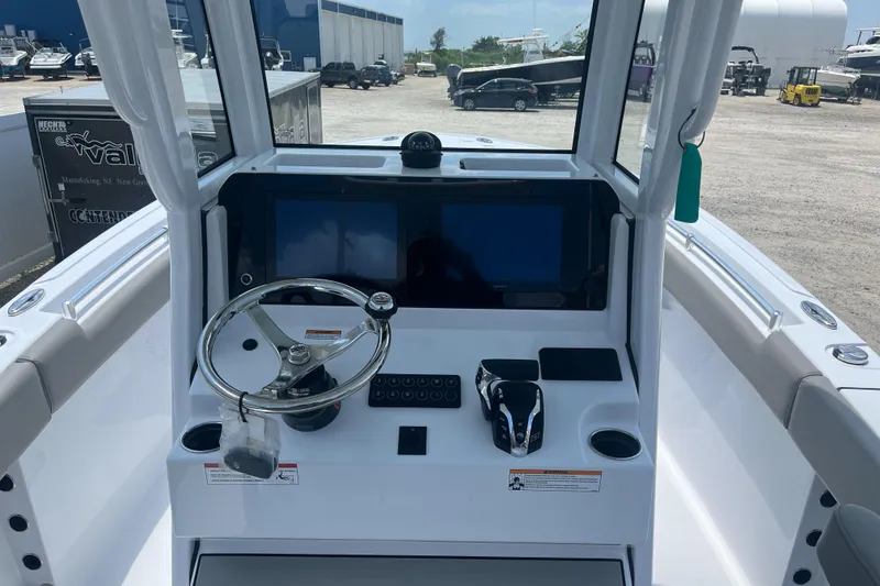 Slide: The Image of 2025 Sportsman Heritage 231 Center Console boat dashboard with steering wheel and controls. - 5
