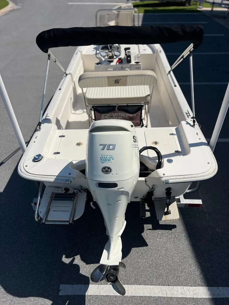 Slide: The Image of 2019 Carolina Skiff 18 JVX CC boat with Suzuki 70 outboard motor, parked on pavement. - 2
