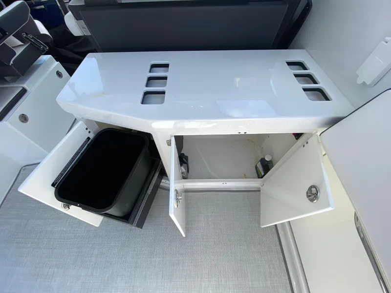 Slide: The Image of 2022 Monterey 378SS boat interior storage compartments with open doors and trash bin. - 23