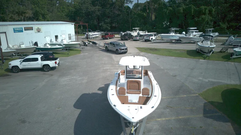 Slide: The Image of 2026 Sea Hunt Ultra 275 SE boat displayed at a dealership with multiple vehicles and boats. - 12
