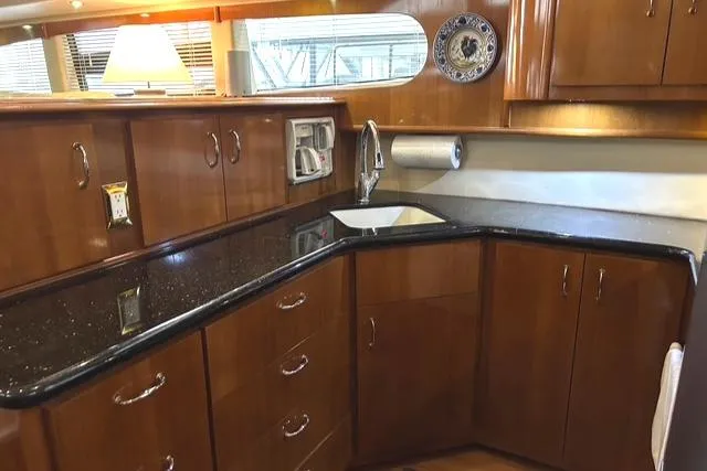 Slide: The Image of Luxurious kitchen interior of 2004 Carver 466 Motor Yacht with wood cabinetry and modern appliances. - 14