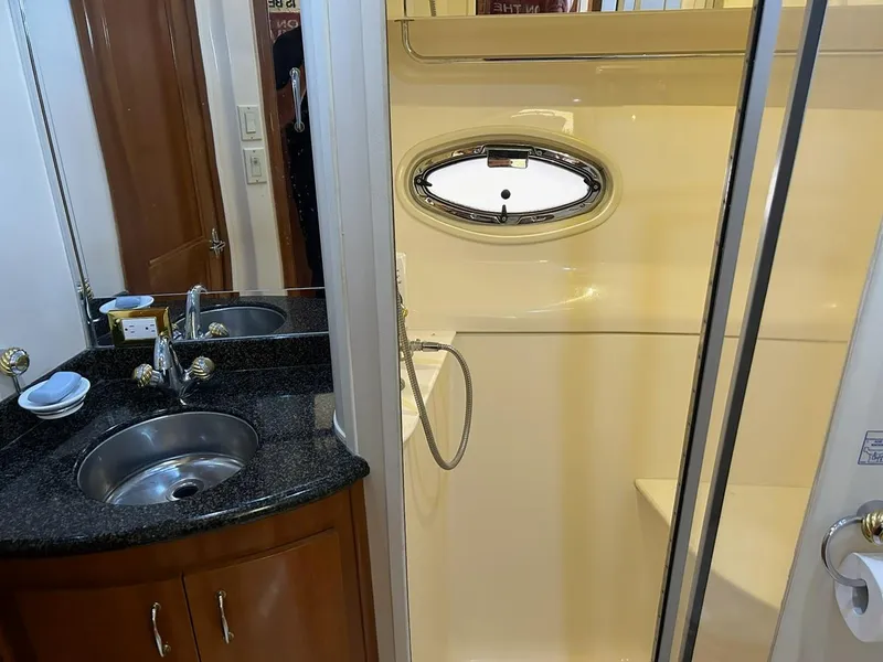 Slide: The Image of 2004 Carver 466 Motor Yacht bedroom with patterned bedding and wooden cabinetry. - 25