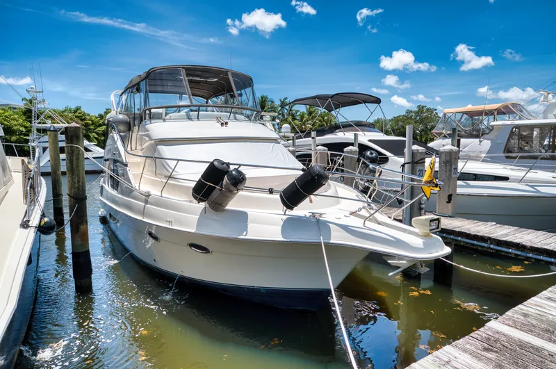Slide: The Image of 2003 Silverton 43 Motor Yacht on a river, surrounded by trees. - 0
