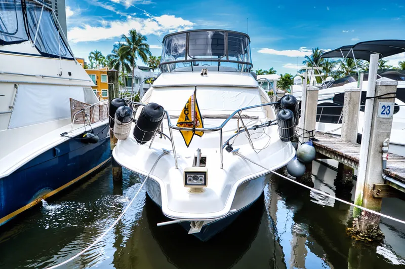 Slide: The Image of 2003 Silverton 43 Motor Yacht docked, surrounded by palm trees. - 13