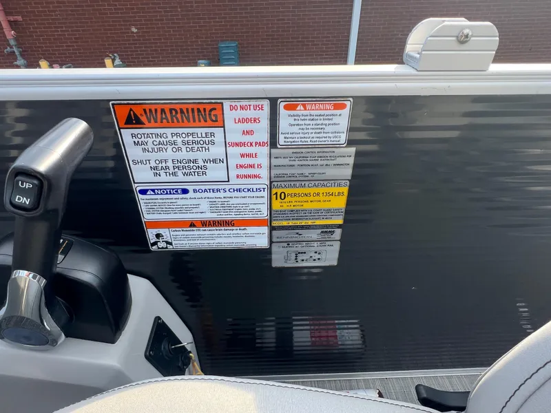 Slide: The Image of Warning labels and controls on a 2022 Bennington SX 20 Swingback boat. - 16