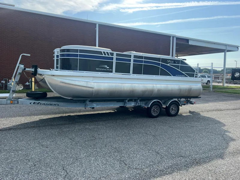 Slide: The Image of 2022 Bennington SX 20 Swingback pontoon boat on trailer, parked outdoors. - 7