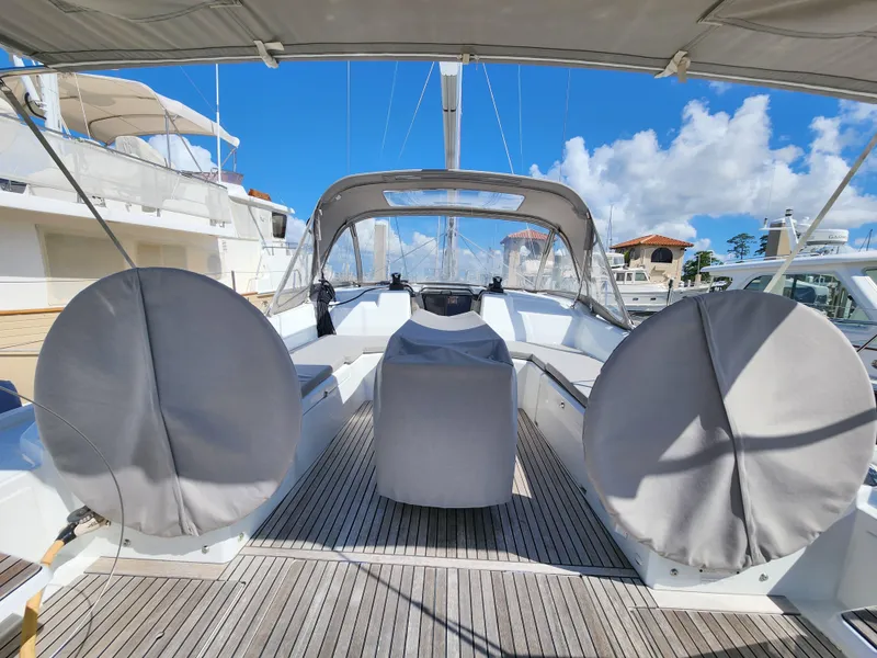 Slide: The Image of 2022 Beneteau Oceanis 40.1 yacht cockpit with covered steering wheels, docked under clear skies. - 13