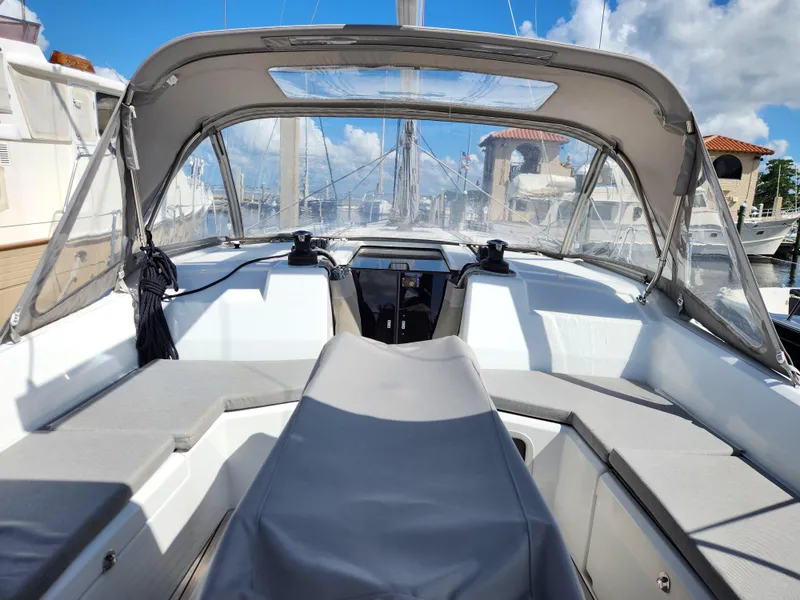 Slide: The Image of 2022 Beneteau Oceanis 40.1 yacht cockpit with canopy, docked at marina under blue sky. - 14